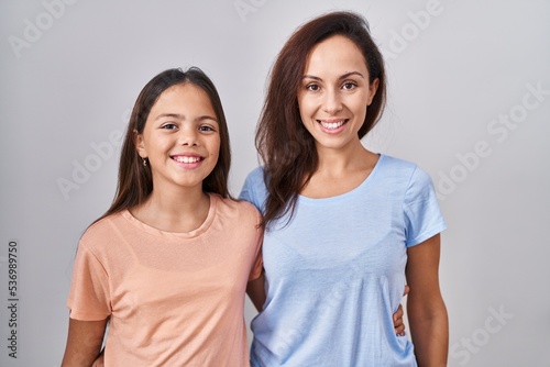 Young mother and daughter standing over white background with a happy and cool smile on face. lucky person.