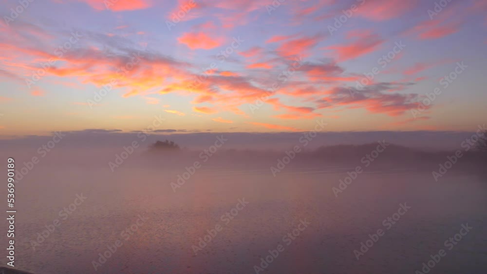 The ship moves along the river during dawn (sunset), the shore is in a light fog. The ship moves along the river during dawn (sunset), the shore is in a light fog.