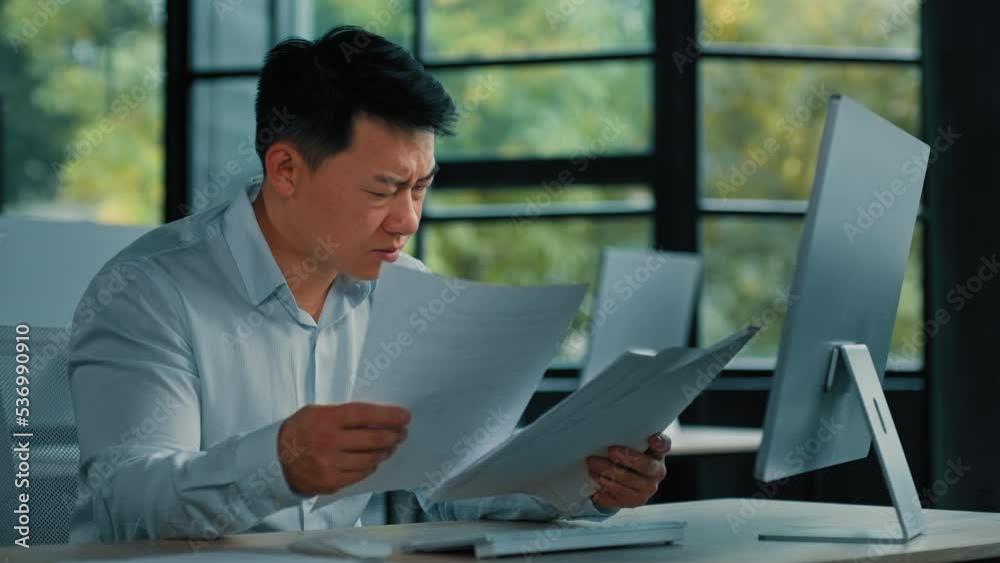 Nervous Asian depressed man lawyer businessman upset senior specialist read financial documents statistical business report work with documentation find mistake difficult task incorrect data in papers Nervous Asian depressed man lawyer businessman upset senior specialist read financial documents statistical business report work with documentation find mistake difficult task incorrect data in papers