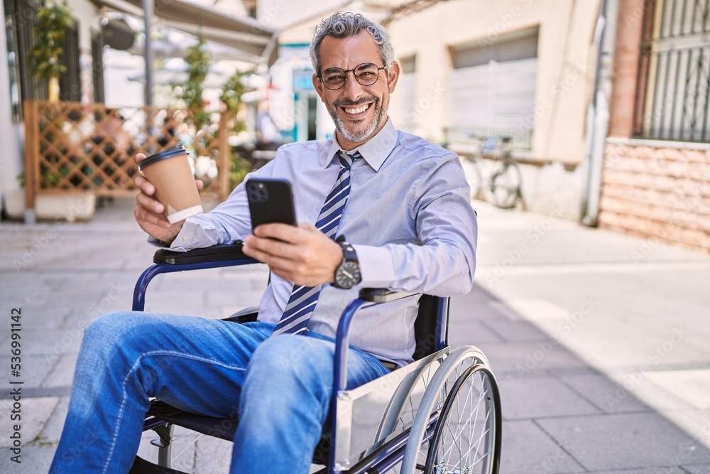 Middle age hispanic man sitting on wheelchair using smartphone at street Middle age hispanic man sitting on wheelchair using smartphone at street