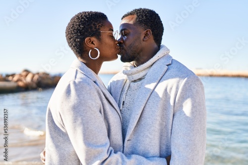 Man and woman couple hugging each other and kissing at seaside