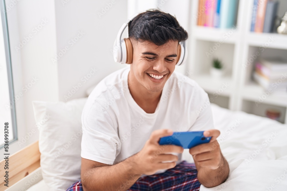 Young hispanic man smiling confident playing video game at bedroom Young hispanic man smiling confident playing video game at bedroom
