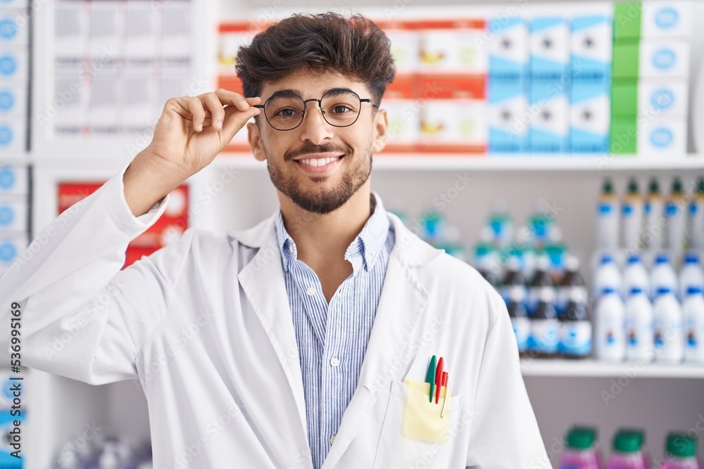 Young arab man pharmacist smiling confident standing at pharmacy Young arab man pharmacist smiling confident standing at pharmacy