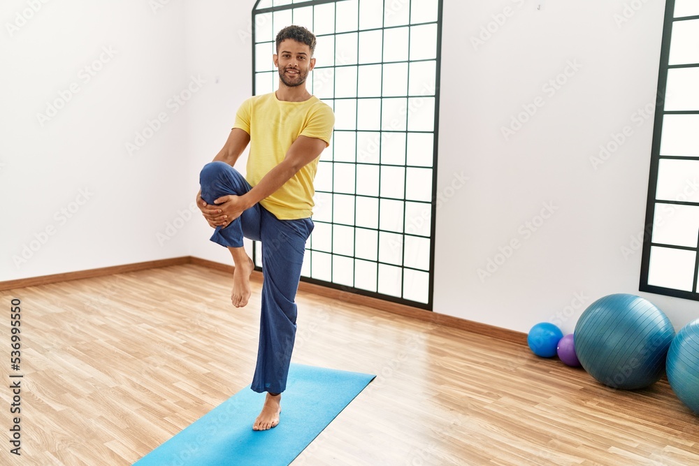Young arab sporty man smiling happy training yoga at sport center.