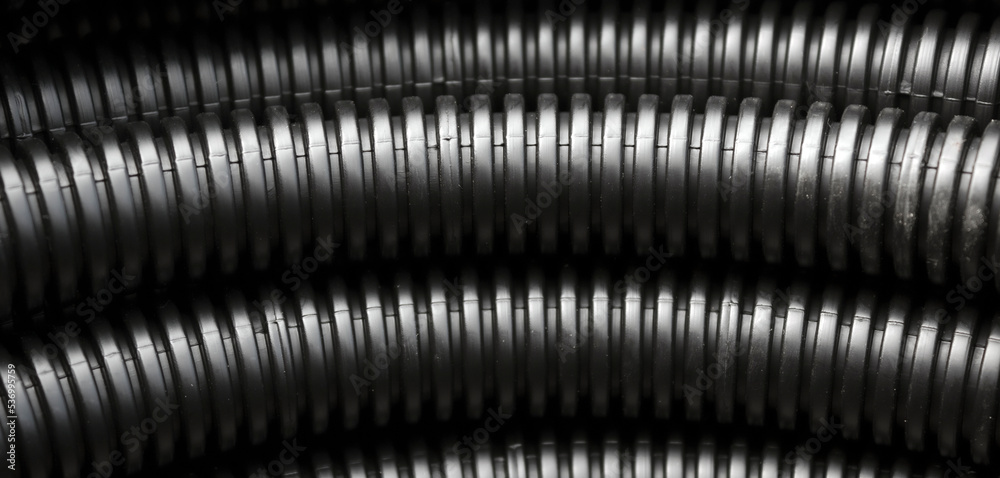 Plastic corrugated pipe. Construction background black tube - obrazy, fototapety, plakaty 