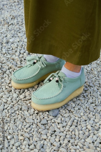Fotografie Female feet wearing wallabees  Clark shoes