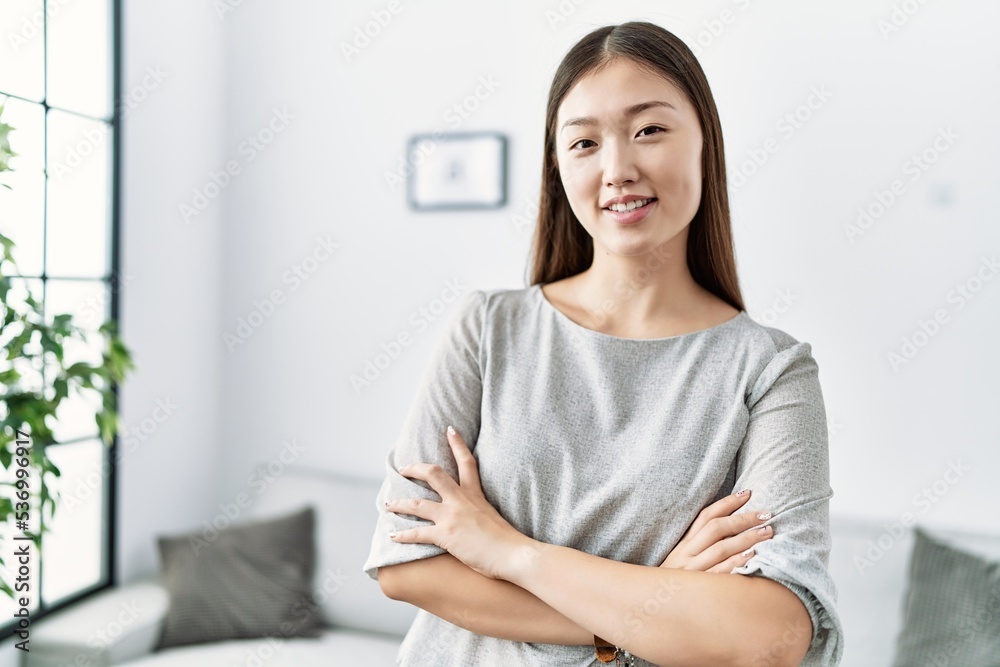 Young asian woman smiling with crossed arms at the living room Young asian woman smiling with crossed arms at the living room