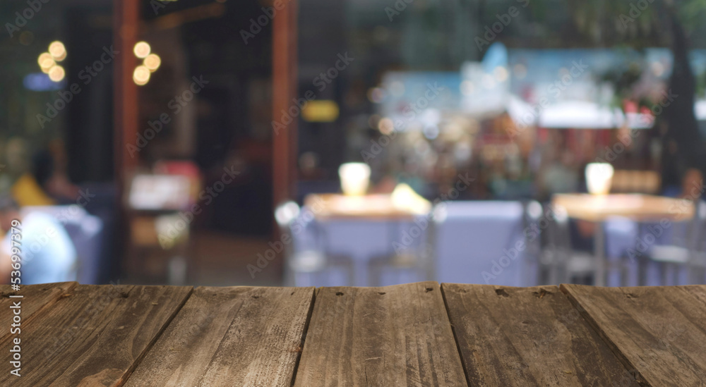 Wood top table with Blur coffee shop or cafe restaurant with abstract bokeh light image background. People in store Blur Background or design key visual layout