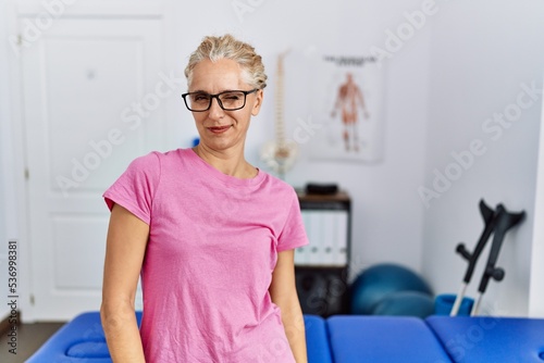 Middle age blonde woman at pain recovery clinic winking looking at the camera with sexy expression  cheerful and happy face.