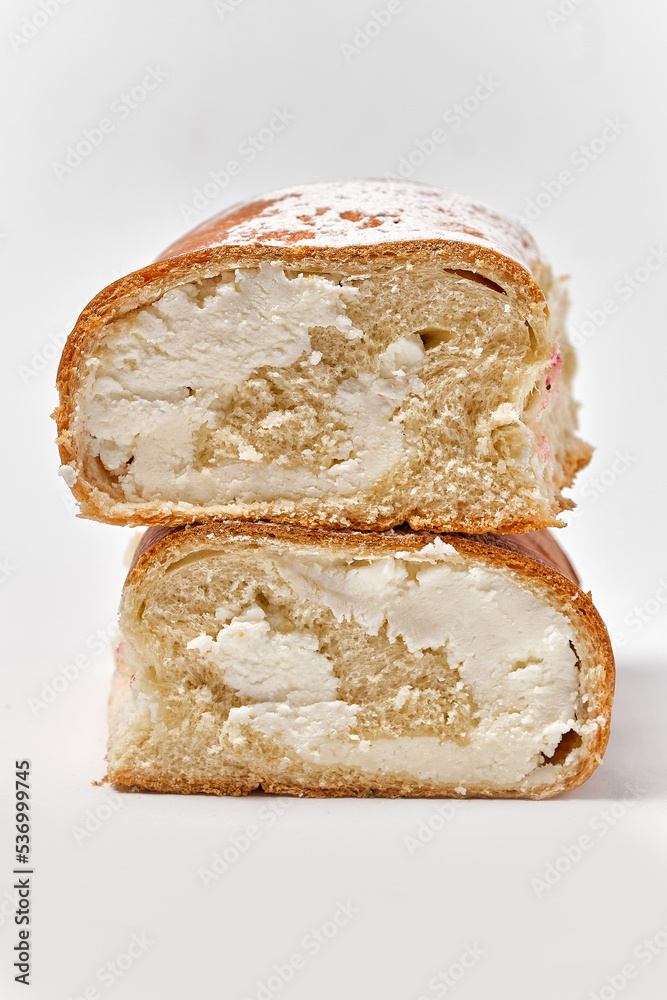 sweet roll with white cream cut in half on a white background sweet roll with white cream cut in half on a white background