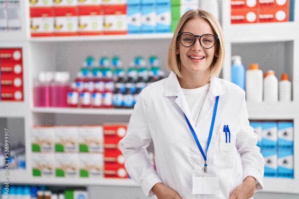 Young blonde woman pharmacist smiling confident standing at pharmacy