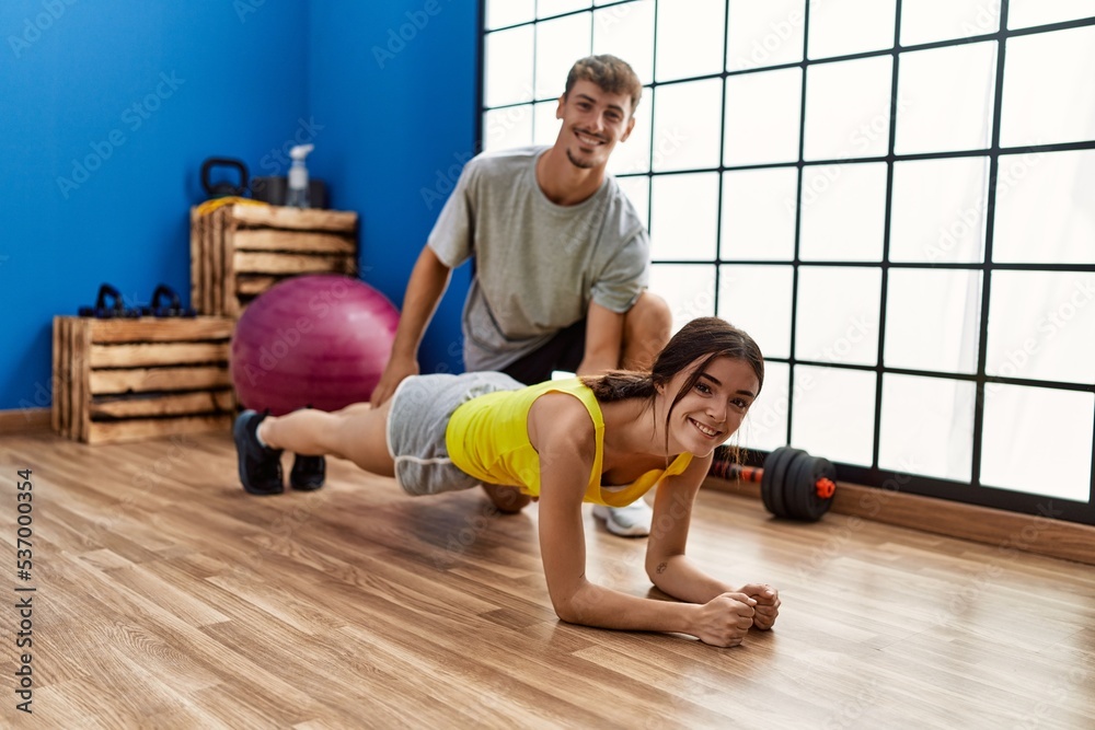Man and woman couple training abs exercise at sport center Man and woman couple training abs exercise at sport center
