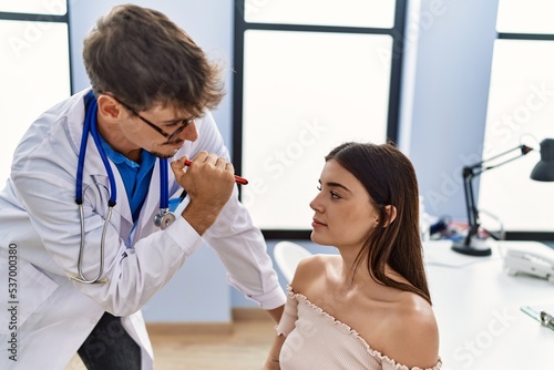 Man and woman wearing doctor uniform auscultating vision at clinic