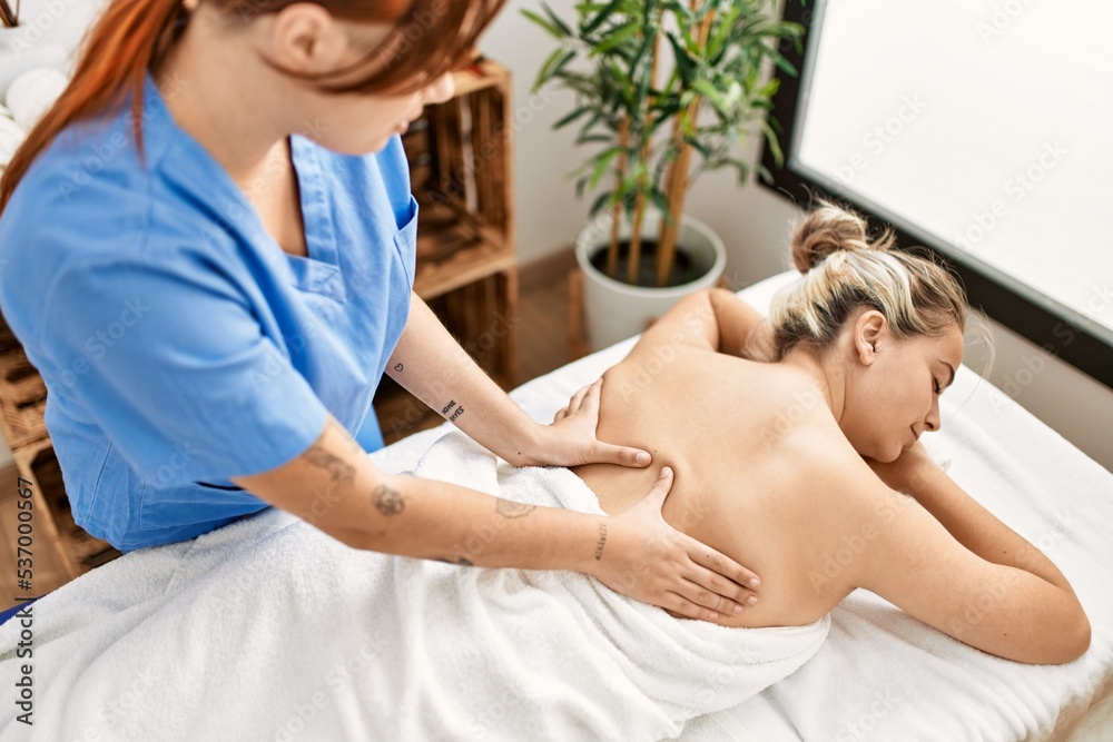 Woman couple smiling confident having back massage at beauty center Woman couple smiling confident having back massage at beauty center
