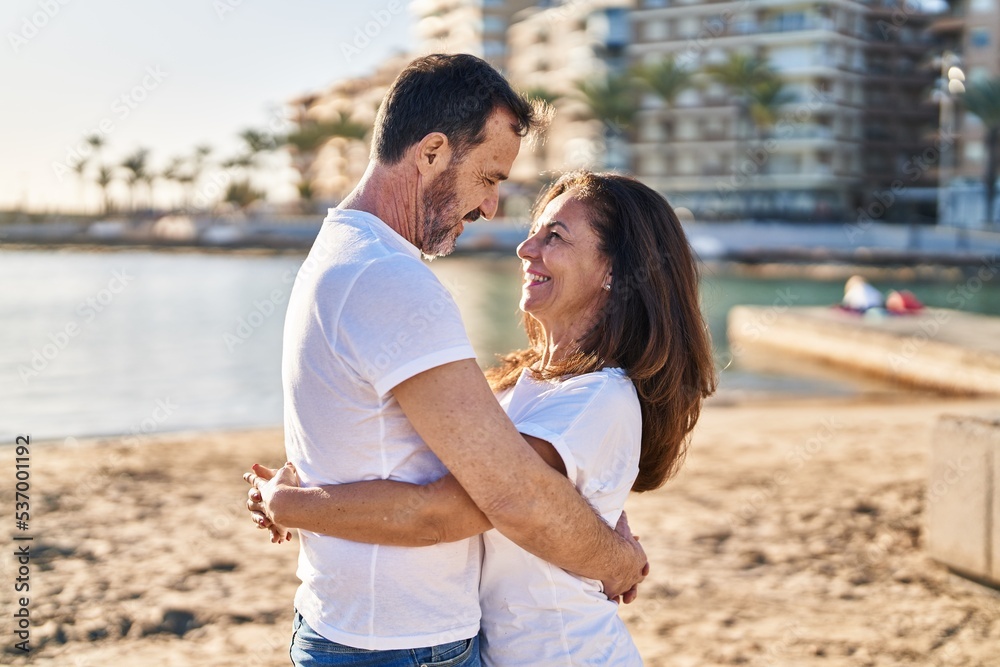 Middle age man and woman couple hugging each other standing at seaside Middle age man and woman couple hugging each other standing at seaside