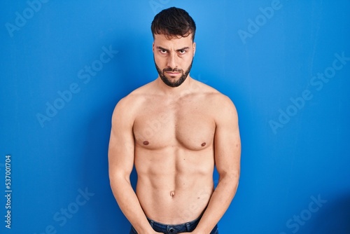 Handsome hispanic man standing shirtless skeptic and nervous, frowning upset because of problem. negative person.