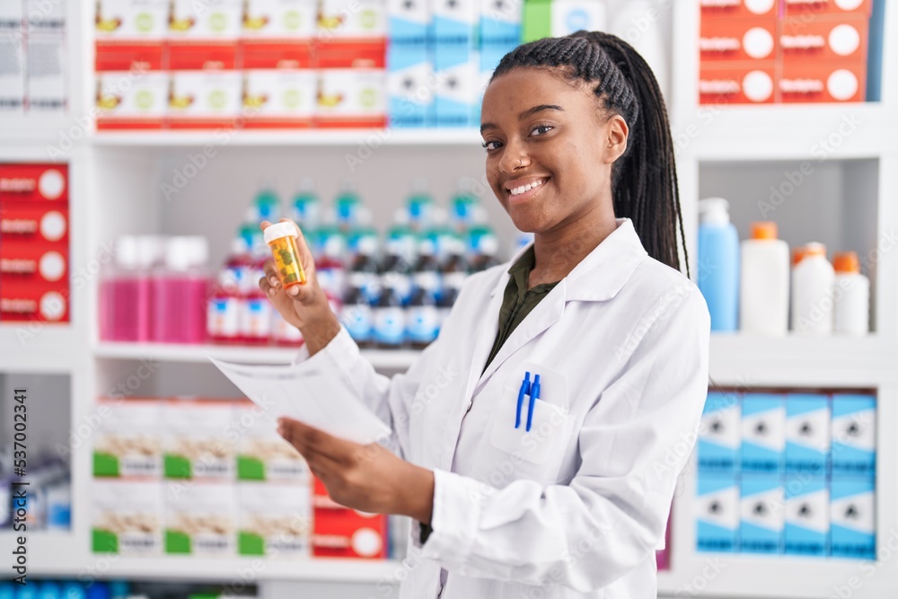 African american woman pharmacist reading prescription holding pills bottle at pharmacy African american woman pharmacist reading prescription holding pills bottle at pharmacy