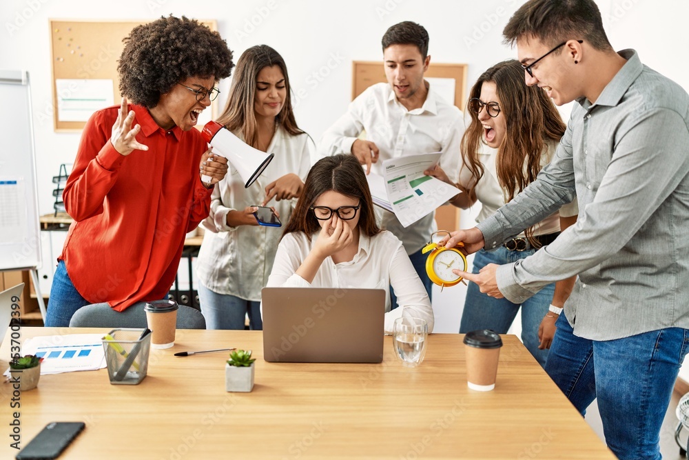 Group of business workers screaming to stressed partner at the office.