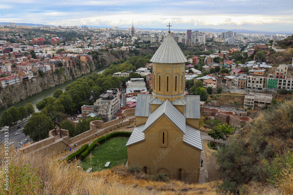 Cathedral on a hill top with city landscape in the background