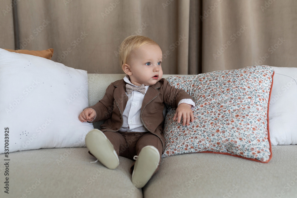 portrait of stylish baby boy sitting on sofa portrait of stylish baby boy sitting on sofa