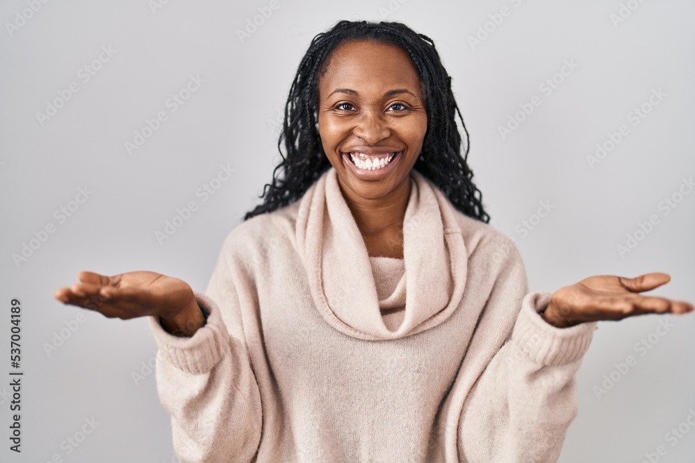 African woman standing over white background smiling cheerful offering hands giving assistance and acceptance.