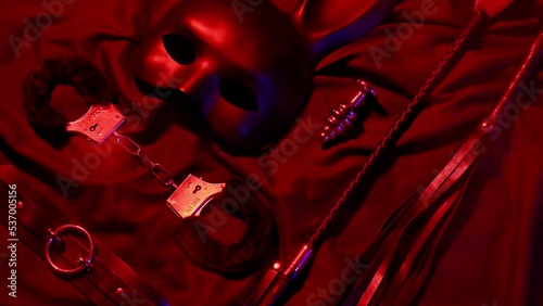 Handcuffs, leather whip flogger, mask and choker for BDSM sex with submission and domination. Concept of erotic adult sex toys