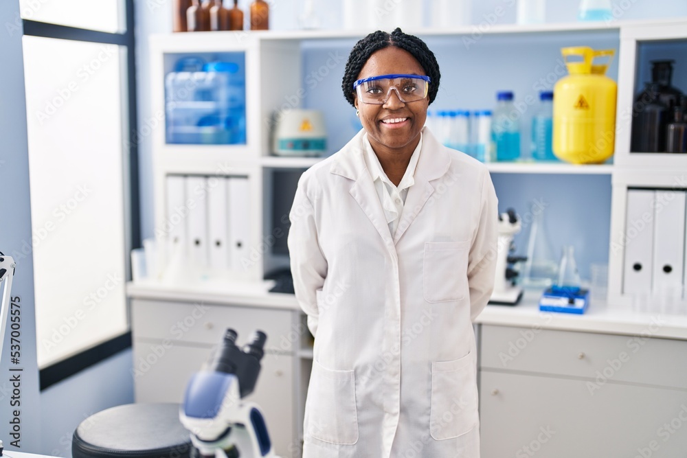 African american woman scientist smiling confident standing at laboratory