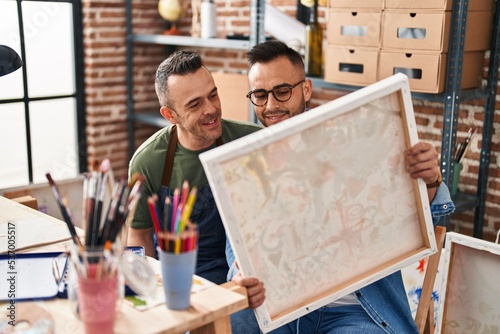 Two men artists smiling confident looking draw at art studio