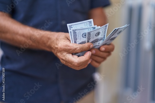 Middle age man counting dollars at street