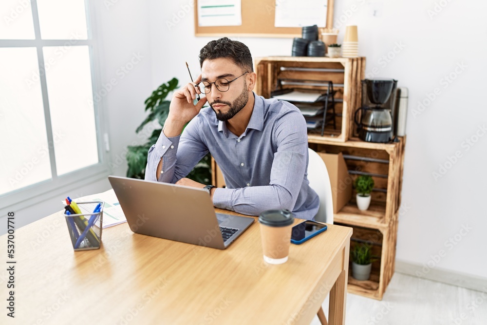 Young arab man using laptop working at office Young arab man using laptop working at office