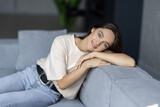 Young attractive woman lying at home living room couch