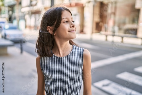 Young hispanic girl smiling outdoor at the town