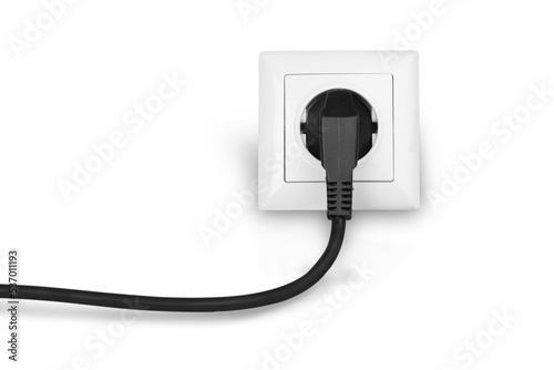 White electrical plug in the electric socket on a wall photo