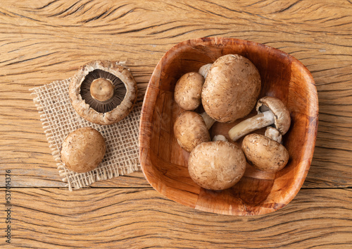 Portobello mushrooms in a bowl over wooden table