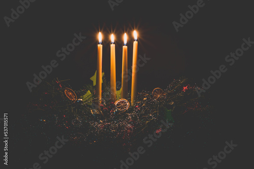 four advent candles burning on advent wreath