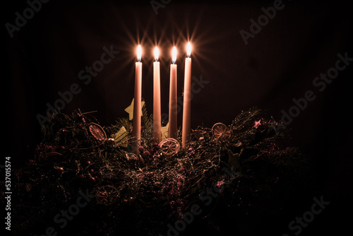 four advent candles burning on advent wreath