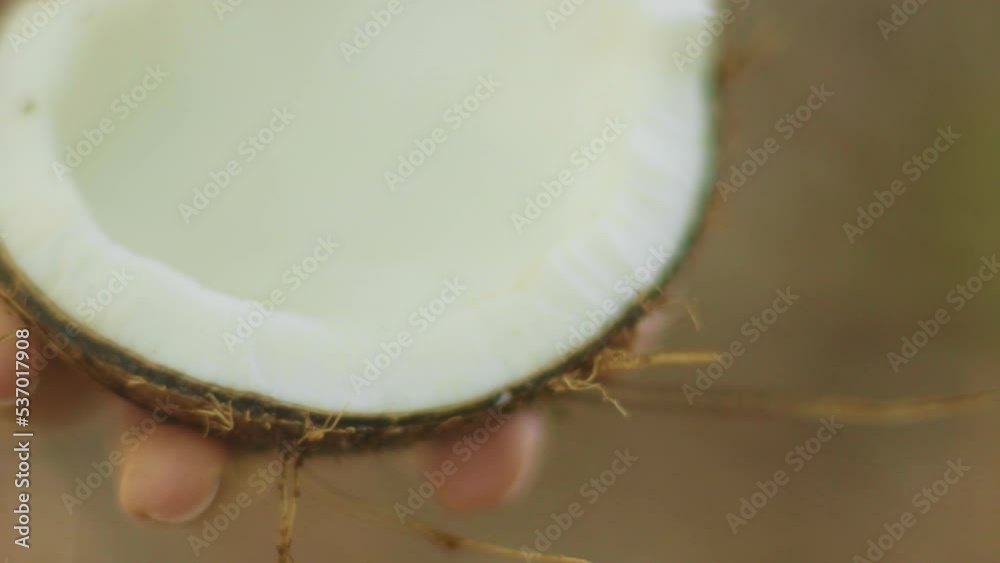 close-up of hand holding coconut with water running down in slow motion close-up of hand holding coconut with water running down in slow motion