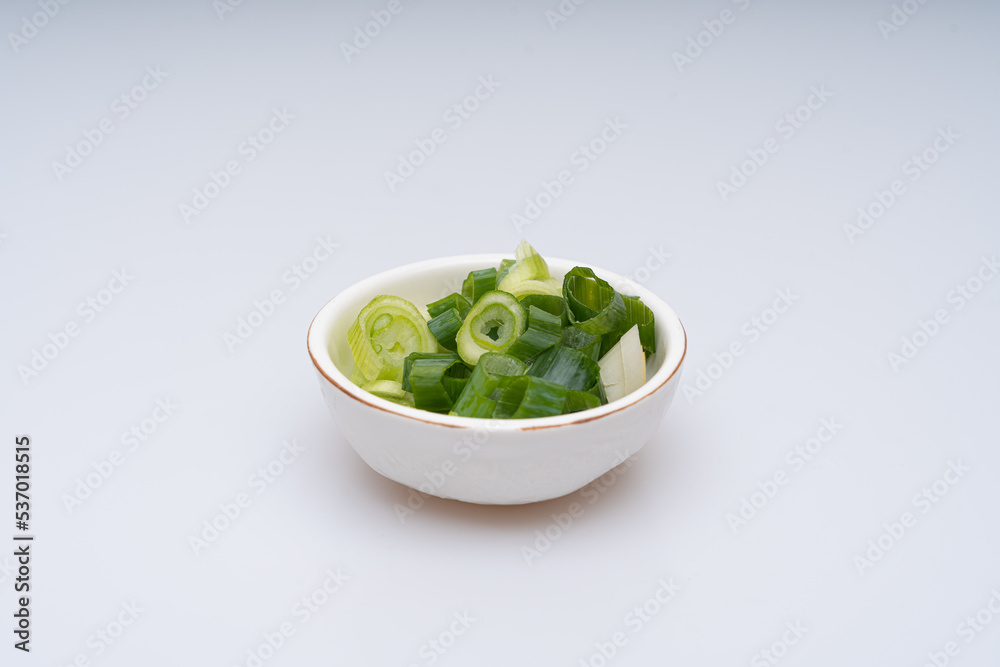 Green onion being trimmed on a white background Green onion being trimmed on a white background