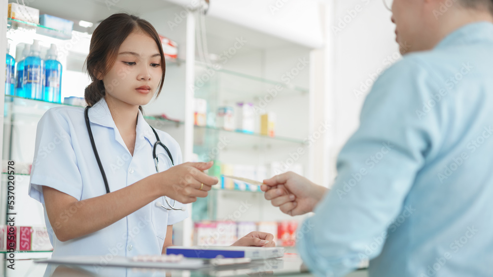 Medicine and health concept, Male client use credit card to buying medicines from female pharmacist