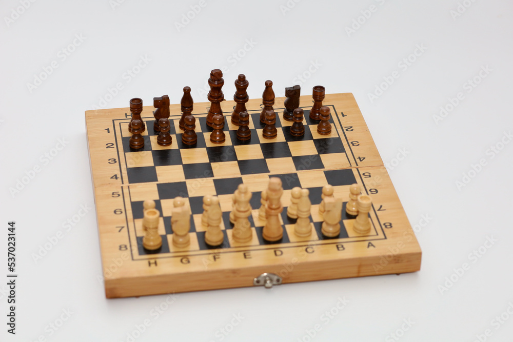 Chess pieces on the chessboard before the game. Beautiful subject photo - chess board with chess pieces before the game on a white background Chess pieces on the chessboard before the game. Beautiful subject photo - chess board with chess pieces before the game on a white background