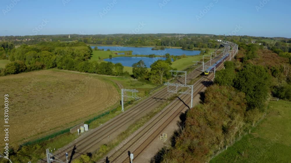 ENGLAND. passenger train passing through countryside. Modern high speed train. High speed passenger railway train South of England, UK. Fast train aerial shot. AERIAL: High speed train train. ENGLAND. passenger train passing through countryside. Modern high speed train. High speed passenger railway train South of England, UK. Fast train aerial shot. AERIAL: High speed train train.