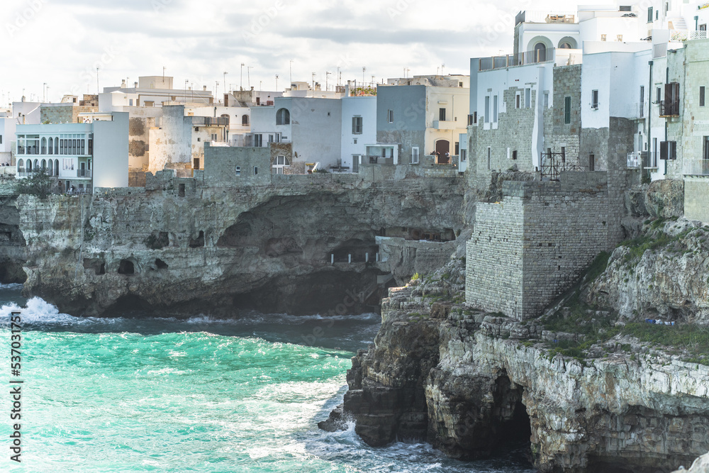 Spectacular houses of the old town of Polignano a Mare built on the cliffs above the Adriatic Sea view from the sea on a beautiful sunny day Spectacular houses of the old town of Polignano a Mare built on the cliffs above the Adriatic Sea view from the sea on a beautiful sunny day