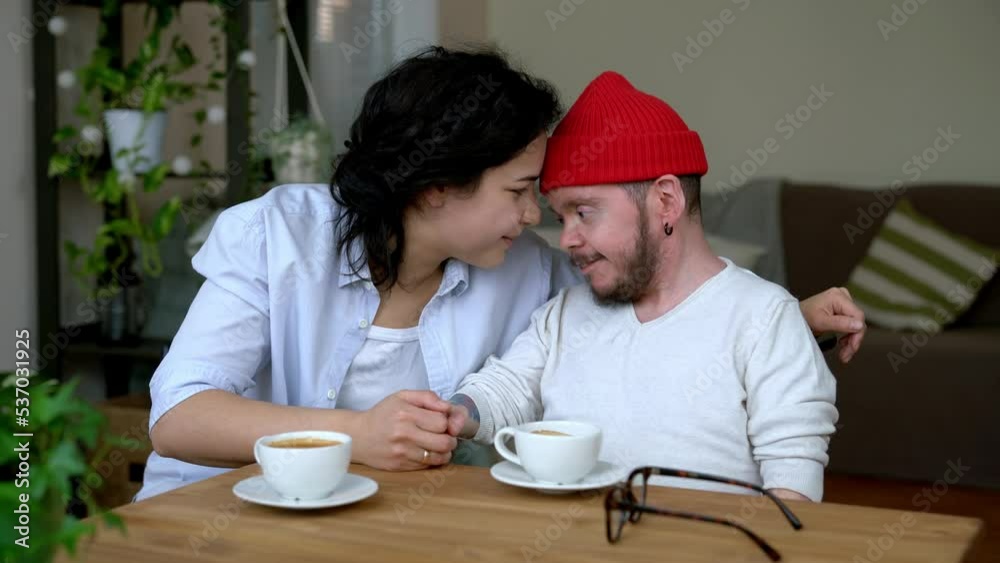 Happy couple sitting at table holding hands kissing Happy couple sitting at table holding hands kissing