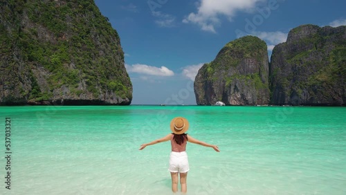 Young woman traveler relaxing and enjoying at beautiful tropical white sand beach at Maya bay in Krabi, Thailand, Summer vacation and Travel concept