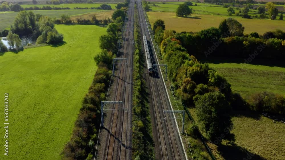 ENGLAND. passenger train passing through countryside. Modern high speed train. High speed passenger railway train South of England, UK. Fast train aerial shot. AERIAL: High speed train train. 
