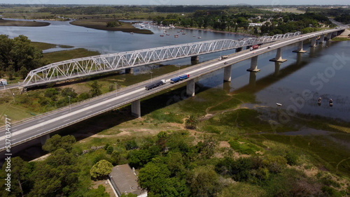 Trucks and cars driving on Barra de Santa Lucia Bridge in Uruguay. Aerial drone view