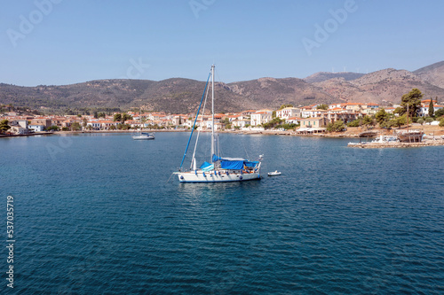 Galaxidi Greece. Sailboat anchored, traditional waterfront houses background.