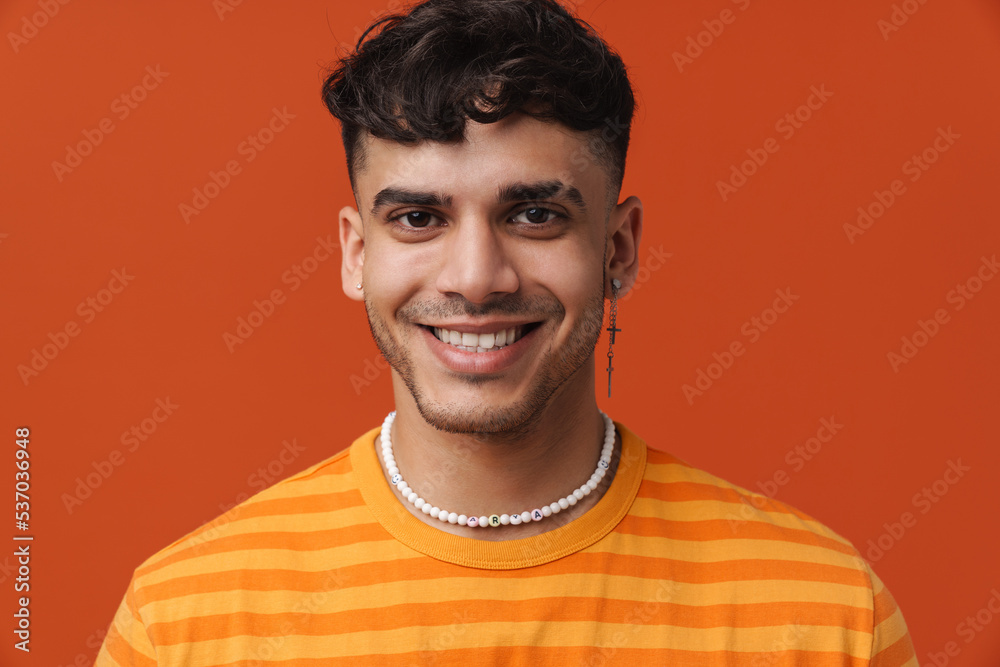 Fototapeta premium Young handsome stylish happy smiling man with piercing in necklace