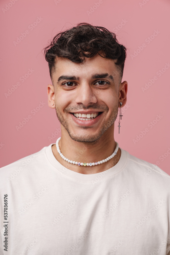 Obraz premium Young handsome stylish smiling man with piercing in necklace