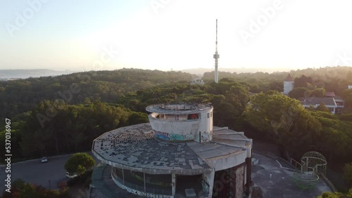Aerial drone view of abandoned restaurant and viewpoint panoramic building in European art deco style the middle of Monsanto forest in Lisbon Portugal.
